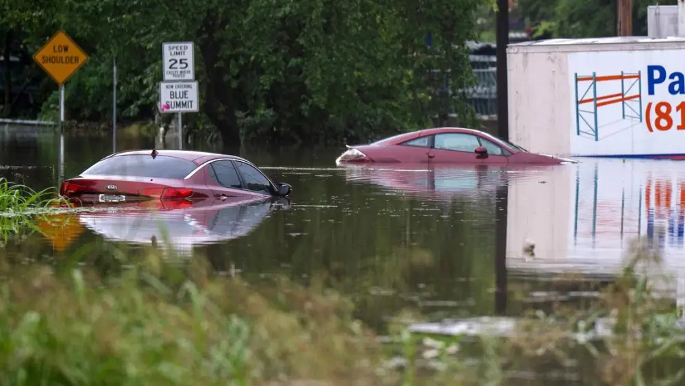 Two vehicles sit nearly fully submerged in floodwaters at Telephone Place and East 23rd Street on Thursday, July 17, 2025, in Kansas City. Heavy overnight rainfall caused flash flooding in parts of the city.